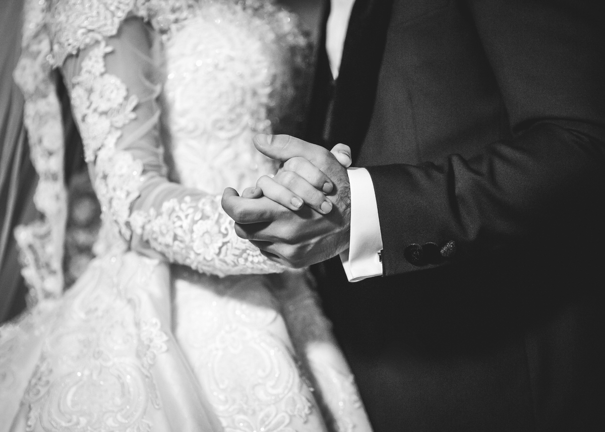 Brautpaar hält sich beim Hochzeitstanz die Hände. Der Fokus des Bildes liegt auf den Händen. Die Gesichter des Brautpaares sind nicht zusehen. Fotografin: Claudia Nürnberger